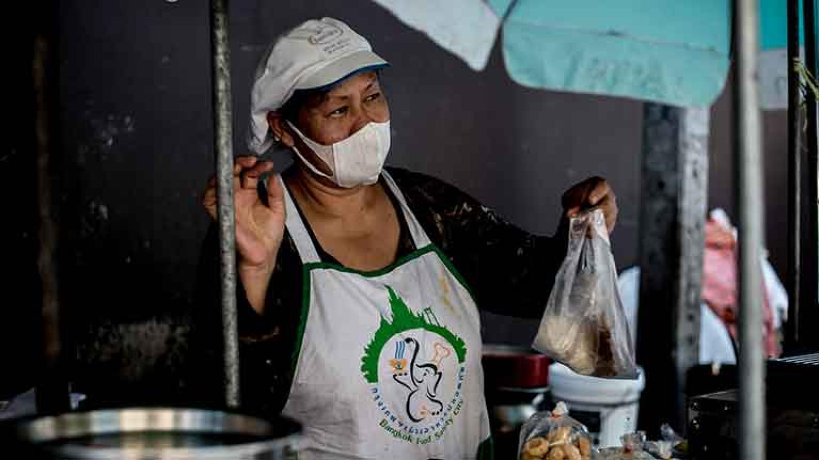 A woman selling food on a green market